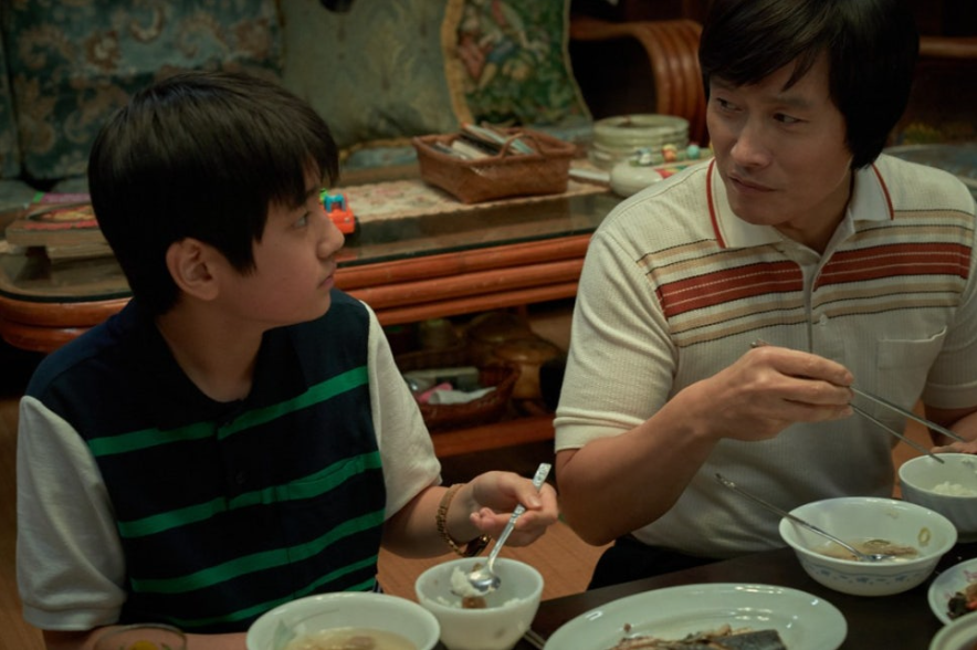 두 사람이 식탁에 앉아 식사하는 모습이다. 어린 소년이 밥그릇을 들고 옆의 남성을 바라보고 있고, 남성은 젓가락으로 음식을 집으며 소년에게 이야기를 건네는 듯하다. 정겹고 따뜻한 분위기를 연출한다.