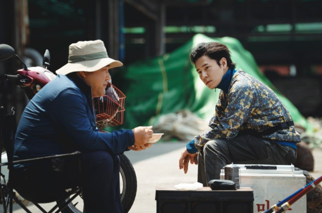 영화 **'보스(BOSS)'**에서 배우 이규형과 고창석이 야외에서 대화를 나누는 일상적인 순간을 담고 있습니다.