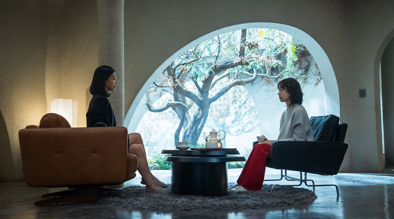 넷플릭스 시리즈 **'트렁크'**의 두 여성 캐릭터가 마주 앉아 팽팽한 탐색전을 벌이는 장면을 담고 있습니다.