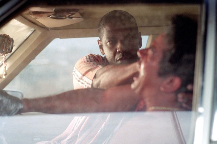 영화 **'맨 온 파이어'**의 한 장면으로, 정보를 얻기 위해 거침없이 폭력을 가하는 주인공의 냉혹한 모습을 담고 있습니다.